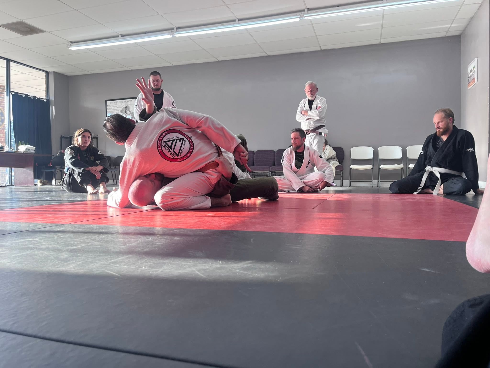 Students watching a partner technique demonstration at Fusion Jiu Jitsu